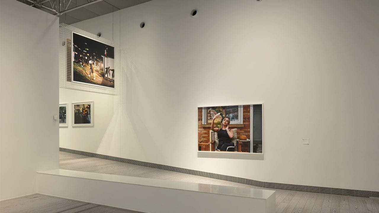 Sala della mostra con fotografie di grande formato della serie Périphérique alle pareti bianche