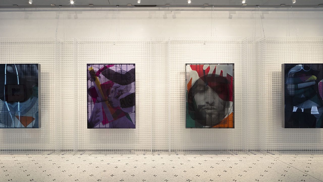 Opere della serie Hands su plexiglass, appoggiate a una griglia metallica bianca