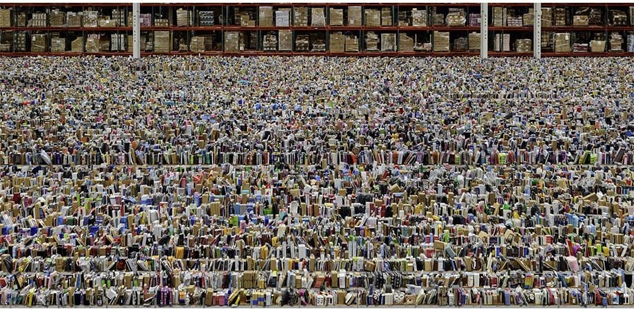Scaffali di un magazzino Amazon colmi di merci colorate, a perdita d’occhio