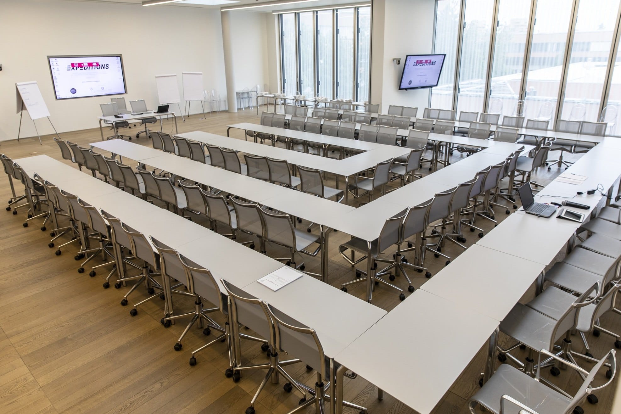 Un’aula dell’Academy con i tavoli disposti a ferro di cavallo, due schermi e le vetrate