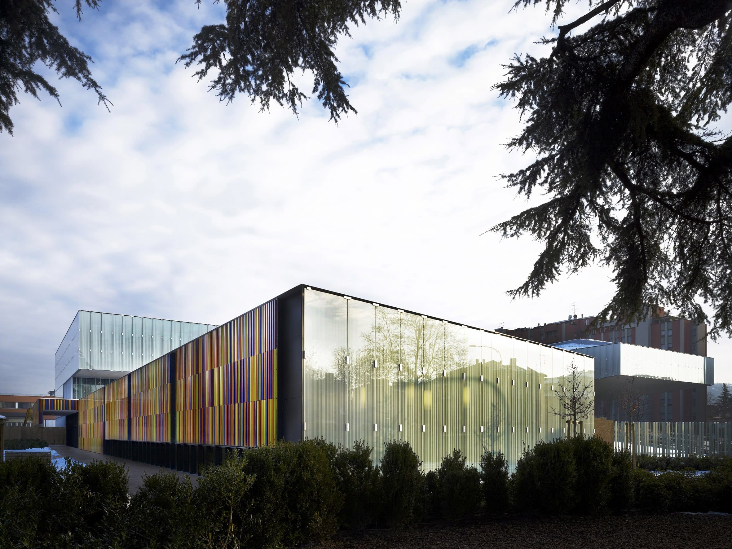 L’edificio del Nido Scuola visto dal giardino, con le lamelle colorate e la parete di vetro