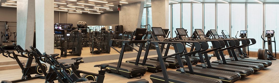 Tapis roulant, cyclette e attrezzi Technogym nella sala con le vetrate